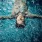 tattooed man floats on his back and relaxes in pool