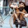 bearded man with sunglasses and a hat kisses the handle bar of his bicycle in town